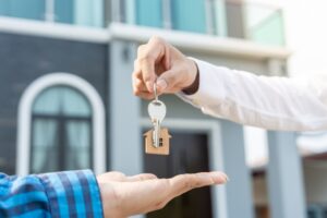 selling home. Real estate agent manager smile holding key for new owner.