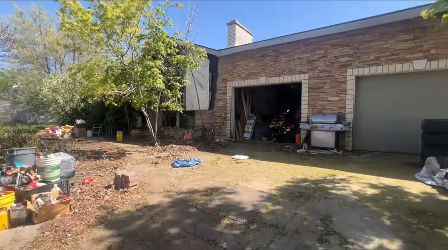 Garage and driveway with belongings remaining, before renovation